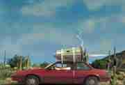 image of waht appears to be a dodge or chevrolet sedan from the mid 80's with a jet engined strapped to the roof